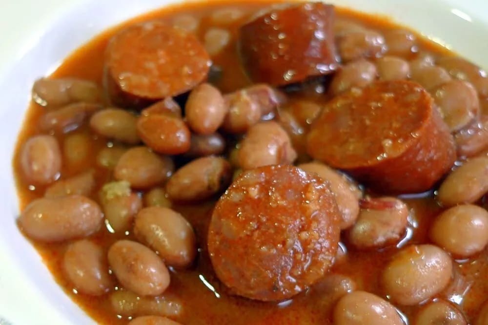 Judías pintas con chorizo y oreja recién servidas en cazuela de barro