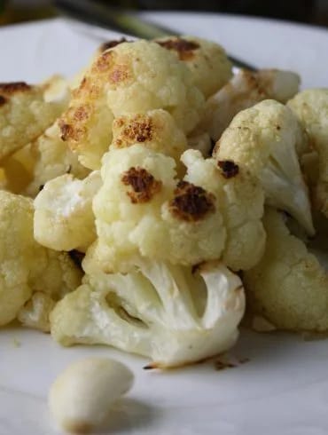 Fuente de coliflor al ajillo gratinada, con las láminas de ajo dorado por encima