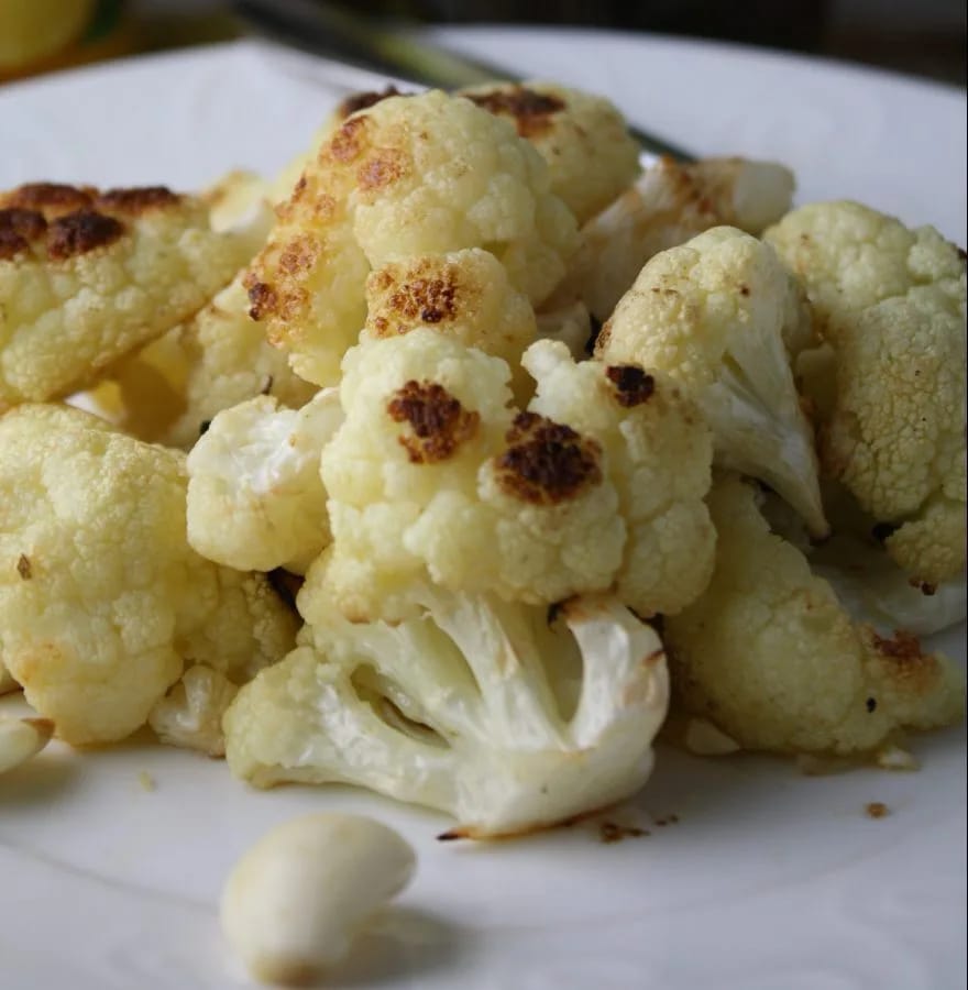 Fuente de coliflor al ajillo gratinada, con las láminas de ajo dorado por encima