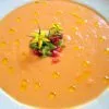 Salmorejo cordobés cremoso y anaranjado con un hilo de aceite de oliva virgen extra y guarnición de verduras