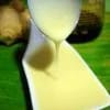 Salsa thai de leche de coco, blanca y cremosa, servida en un cuenco