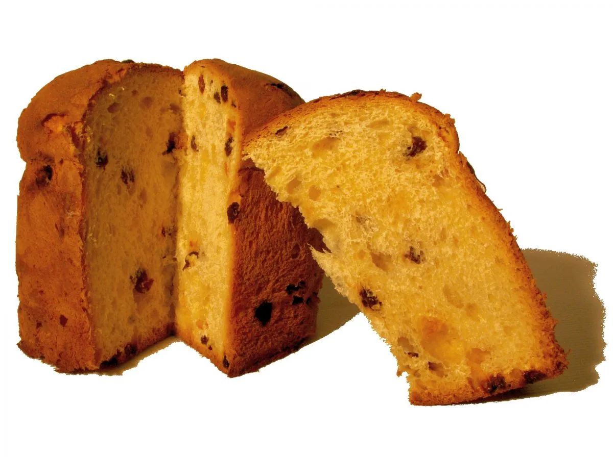 Panettone clásico cortado con dos cuñas separadas enseñando la miga esponjosa con pasas, sobre fondo blanco