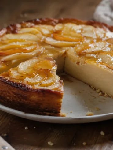 Tarta de manzana y melocotón cortada: el interior es liso y denso, como un flan horneado, con rodajas de fruta pelada en abanico y brillo de mermelada por encima