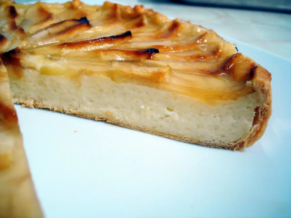 Porción de tarta de manzana con hojaldre y natillas mostrando sus capas