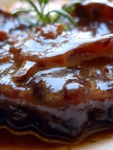 Plato de rabo de toro guisado con salsa espesa y patatas fritas caseras