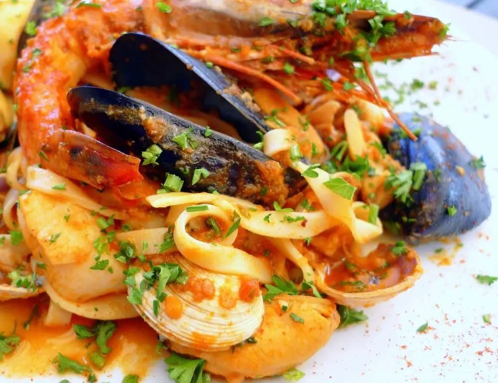 Plato de tallarines a la marinera con mejillones, almejas, calamar y langostinos en salsa de tomate
