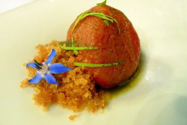 Tomate escarchado con tierra caliza, pesto y hojas tiernas de Alliaria de rio.