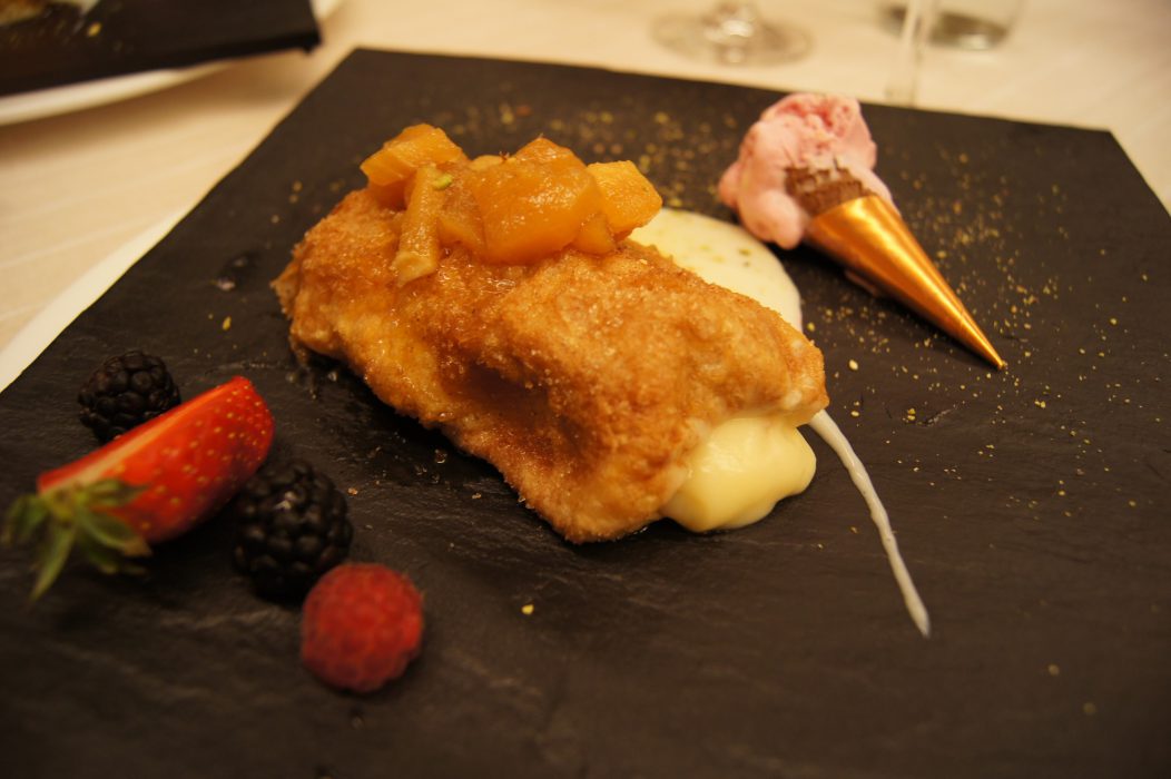 Torrija rellena de crema, manzana caramelizada, frutos rojos, polvo de pistacho y helado de fresa