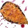 Berenjenas rellenas de carne picada gratinadas con queso, servidas en una fuente de horno