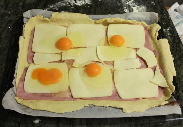 Cascamos los huevos y con cuidado los colocamos encima del queso.