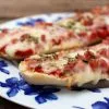 Panini de queso y beicon de cerca, con la mozzarella fundida y el beicon dorado