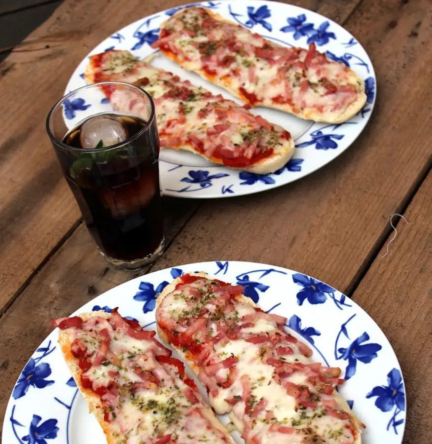 Dos platos de paninis de queso y beicon en la mesa, listos para la cena