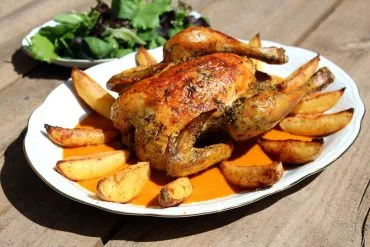 Pollo asado al horno entero y dorado sobre puré de verduras asadas