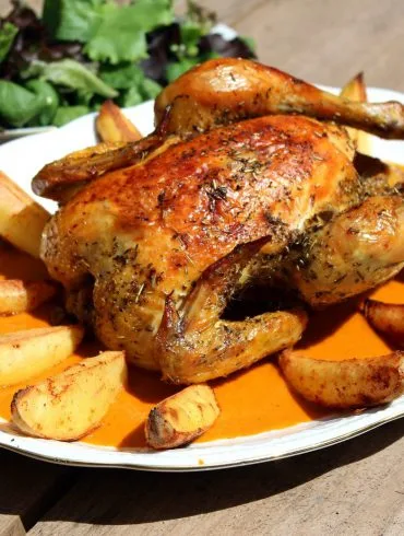 Pollo asado al horno entero y dorado sobre puré de verduras asadas