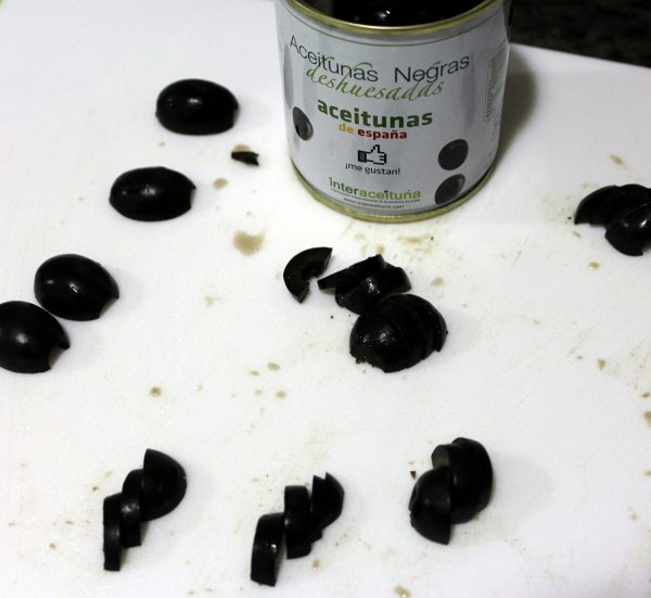 Mientras prepararemos las arañas de aceitunas negras y los ojos de las momias. Para ello nos hará falta una aceituna y media para cada una de las arañas y dos aceitunas negras que cortaremos en rodajas, que harán de ojos.