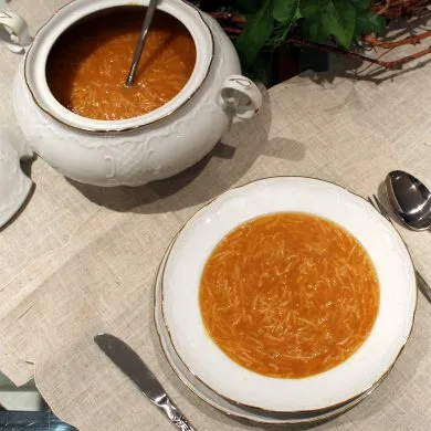 Caldo casero tradicional dorado, servido en un cuenco, base de sopas y guisos