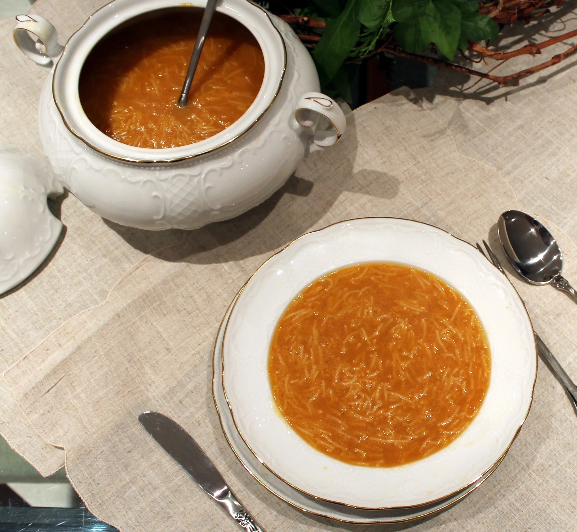 Caldo casero tradicional dorado, servido en un cuenco, base de sopas y guisos
