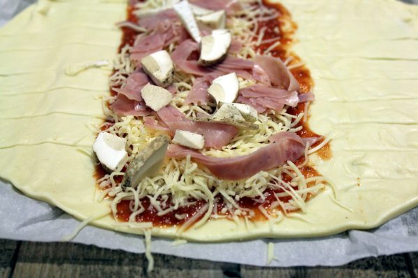 Cubrimos esas franjas con el tomate especial para pizza y encima cebolla caramelizada.
