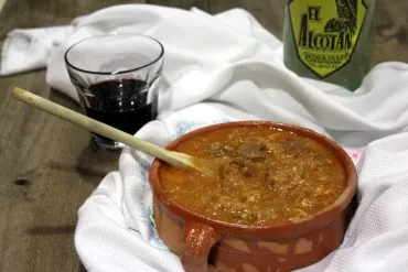 Sopa castellana tradicional con pan, pimentón y huevo, servida en un cuenco de barro