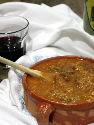 Sopa castellana tradicional con pan, pimentón y huevo, servida en un cuenco de barro