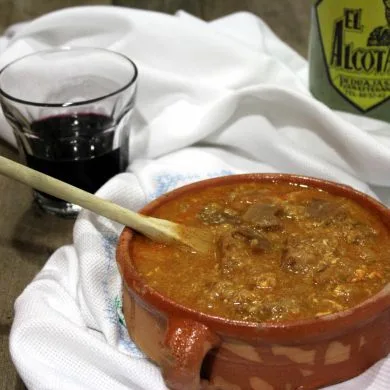Sopa castellana tradicional con pan, pimentón y huevo, servida en un cuenco de barro