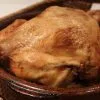 Pollo al horno tradicional dorado en cazuela de barro con su jugo