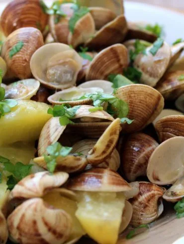 Chirlas al ajillo con patatas servidas en cazuela, con perejil picado