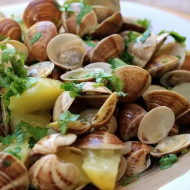 Chirlas al ajillo con patatas servidas en cazuela, con perejil picado