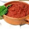 Cazo con salsa de tomate para pizza recién reducida, espesa y de color rojo intenso