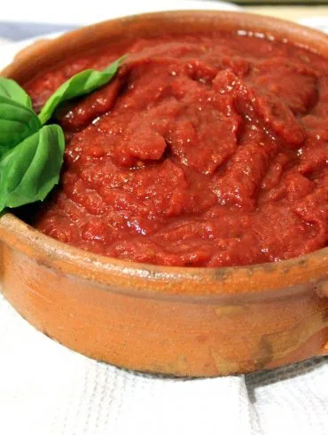 Cazo con salsa de tomate para pizza recién reducida, espesa y de color rojo intenso