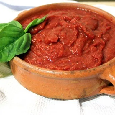 Cazo con salsa de tomate para pizza recién reducida, espesa y de color rojo intenso