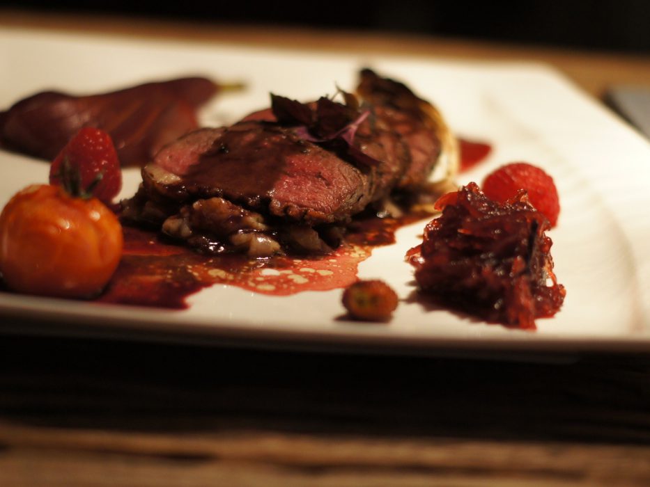 Magret de pato sobre salsa de boletus con pera al vino, cebolla roja caramelizada, endivia y frutos rojos