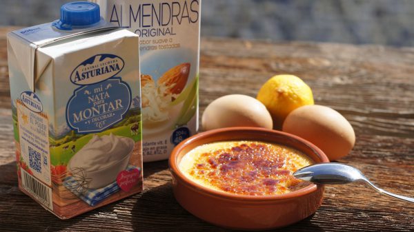 Ponemos a calentar en un cazo la leche y la nata con las ralladuras de naranja y limón, con la rama de canela y la vaina de vainilla.  