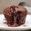 Dos coulants de chocolate servidos, uno entero y otro partido mostrando el corazón líquido