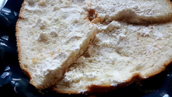 Quitamos las frutas escarchadas de la parte superior del Roscón de Reyes. Levantamos dicha parte y retiramos la nata de su interior, a un cuenco, con la ayuda de una cuchara. 