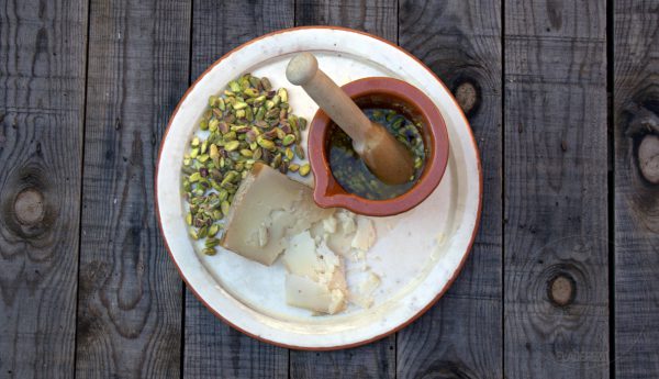 Mientras preparamos la picada de pistachos y queso de oveja curado. Para ello machacamos un poco los pistachos en un mortero. Añadimos el aceite y el queso. Machacamos nuevamente unos segundos.