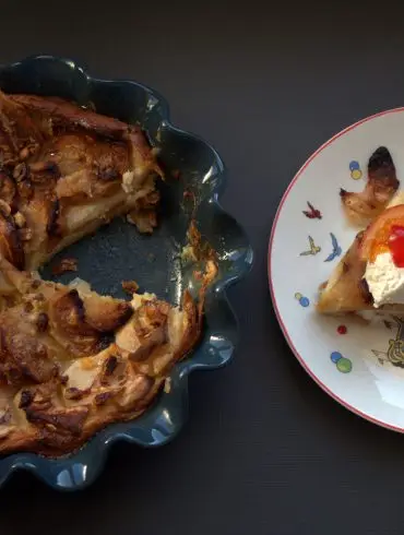Ración de pudin de roscón de Reyes con una quenelle de nata y fruta escarchada, junto al pudin entero en su molde