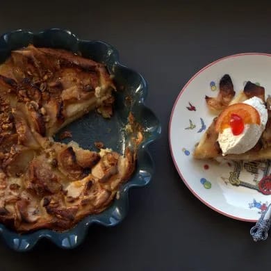 Ración de pudin de roscón de Reyes con una quenelle de nata y fruta escarchada, junto al pudin entero en su molde
