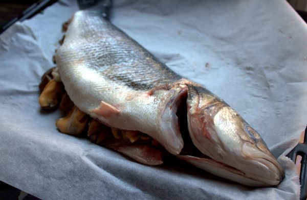 Repartimos el salteado de las setas sobre una mitad de la lubina y encima los mejillones. Cubrimos con la otra parte de la lubina. 