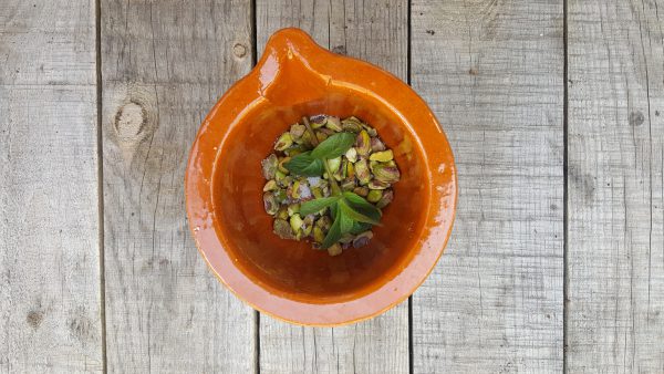 En lo que alcanza la temperatura, nos ponemos con la picada de pistachos y menta. Para ello machacamos en el mortero unas 8 hojas de hierbabuena. Añadimos los pistachos y machacamos nuevamente.