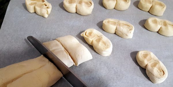 Con ayuda de un cuchillo bien afilado, cortamos porciones de un centímetro y medio, más o menos, y colocamos sobre una bandeja de horno, dejando espacio suficiente para que doblen su volumen, a la que habremos puesto encima una hoja de papel de hornear.