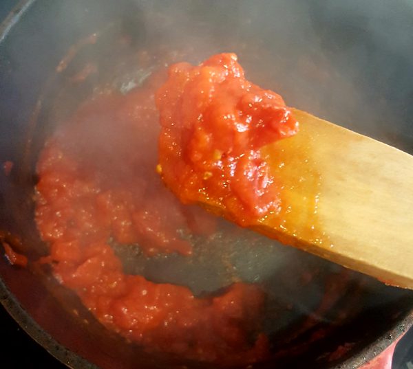 Ponemos a calentar en una cazuela el aceite de oliva. Cuando esté caliente añadimos la cebolleta. Pochamos un par de minutos e incorporamos el tomate.