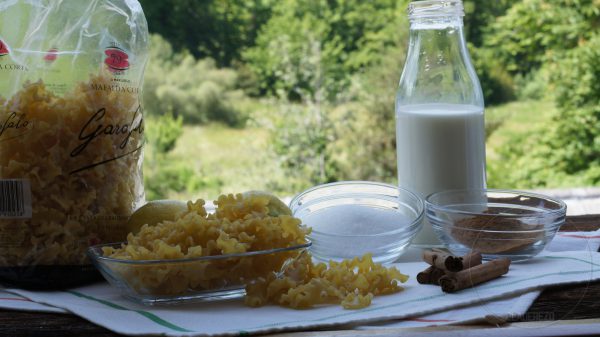 En una cazuela llevamos a ebullición a fuego suave la leche con el azúcar, la corteza de limón y la canela en rama.