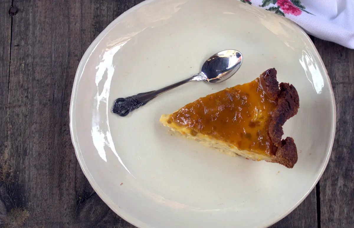 Porción de tarta de queso y mango al horno vista desde arriba, con su cobertura de mermelada y el borde de masa dorado