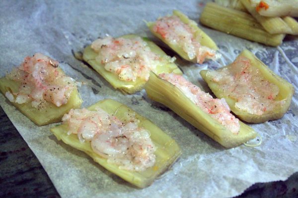 Cogemos un trozo de penca de cardo, colocamos un poco del carpaccio de gamba, cubrimos con otro trozo de cardo, a modo de bocadillo. Repetimos esta operación hasta que se nos acabe el cardo o el relleno de gamba.