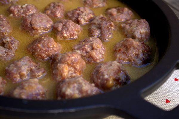 En lo que se hacen las albóndigas al fuego, colocamos las patatas en una fuente, esparcimos un poco de tomillo o romero fresco por encima y calentamos en el horno durante 10 minutos.