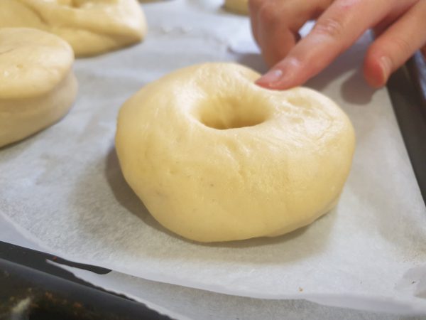 Una vez que tenemos cortados la masa en forma de donuts los colocamos sobre una bandeja con papel de horno y cubiertos con un paño. Dejamos levar durante otra hora.