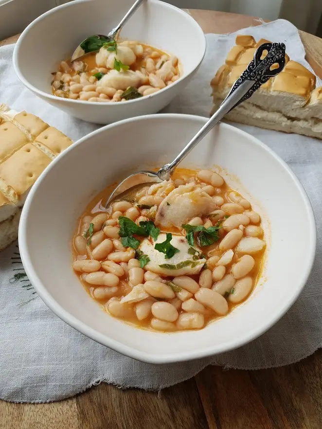 Cazuela de alubias blancas guisadas con carrilleras de bacalao y perejil picado por encima