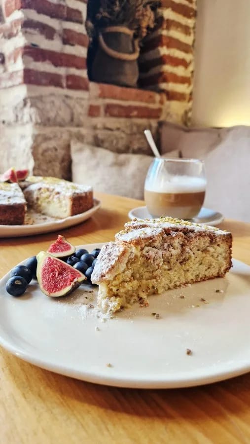 Bizcocho de pistacho y cardamomo cortado, con granillo de pistacho y azúcar glas