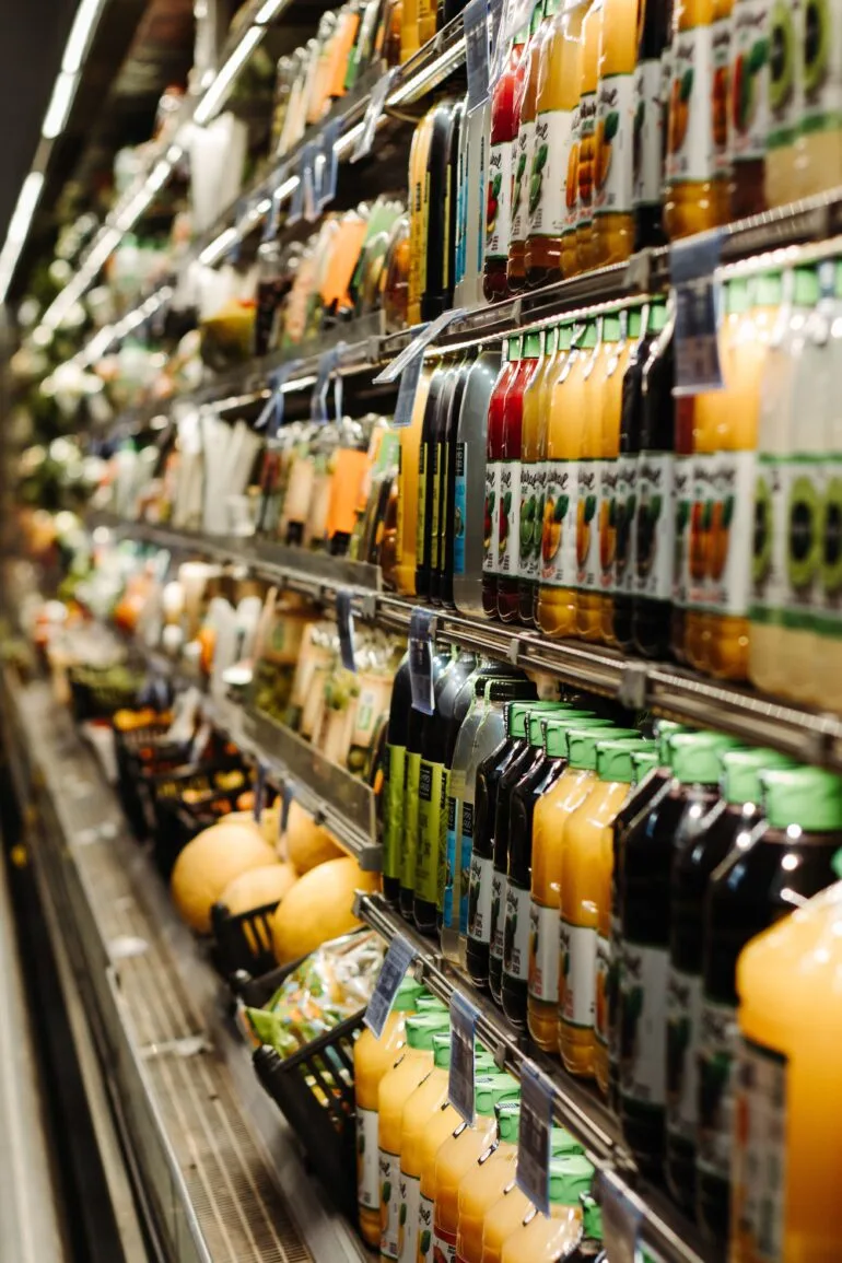 Estantería de supermercado llena de botellas y latas de bebidas